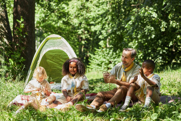 istock Group of scouts camping together in forest lit by sunlight 1485543905