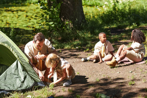 istock Group of scouts setting tent during hiking trip in forest 1485546209