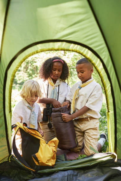 istock Group of three young scouts putting up tent in forest 1485546254