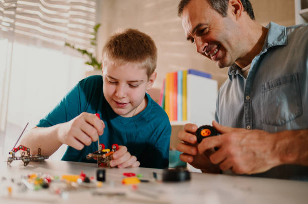 istock Happy father helping his young son while assembling the toy together. 1485546346