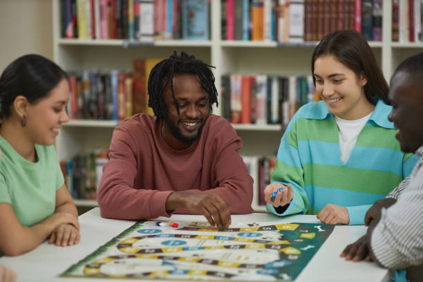 istock Group of young people playing board games together in library 1485548918