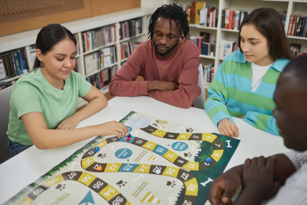 istock Group of students playing board games together in library 1485548958
