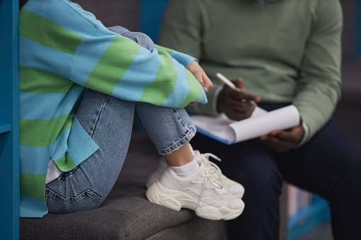 Closeup of stressed teenage girl talking to therapist in session