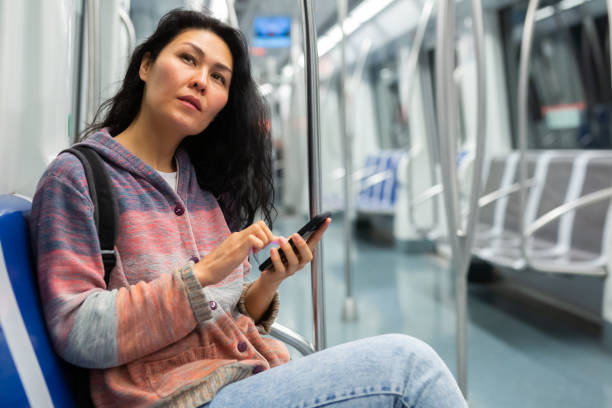 istock Woman with suitcase and sitting on bench in subway train and using smartphone 1485549669