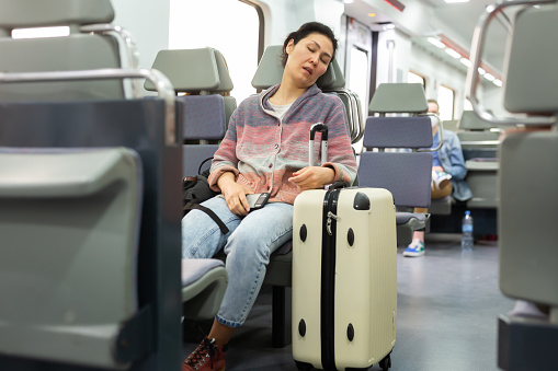 Portrait of sleepy Asian girl in a subway car