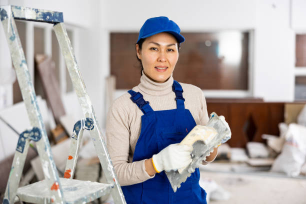 istock Smiling female repairer with float trowel standing indoors 1485549739