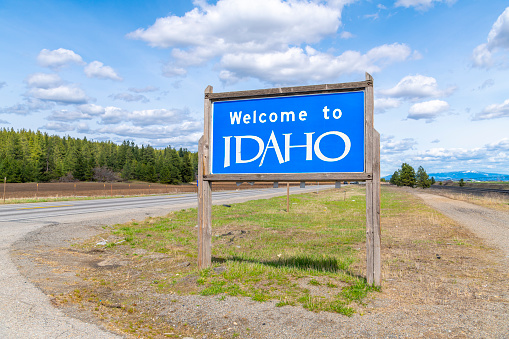 A Welcome to Idaho roadside sign on a country road in a rural area of North Idaho near Coeur d'Alene and Post Falls Idaho, coming from Washington state at Newman Lake near the Spokane area.