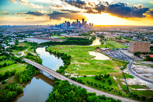 The skyline Houston, Texas at sunset on an early spring evening shot from an altitude of about 600 feet over the East End District, also known as Eado, with the Buffalo Bayou snaking its way toward the city center.