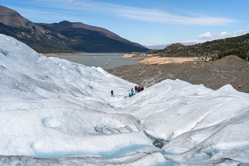 A group of people are finishing a long and impressive hike on the Perito Moreno Glacier in Argentina.