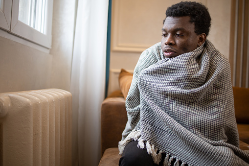 Young man feel cold in home with no heating