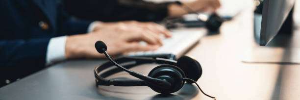 istock Panorama focus headset on call center workspace desk with blur operator. Prodigy 1485586554