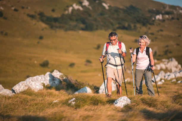 istock Happy Senior Couple Walking Side By Side With Hiking Gear 1485593464