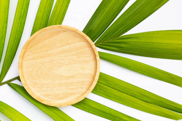 istock Empty wooden plate on tropical palm leaves 1485600236