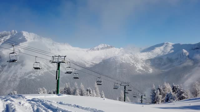 Empty Ski Chairlift climbs snowy mountain peak
