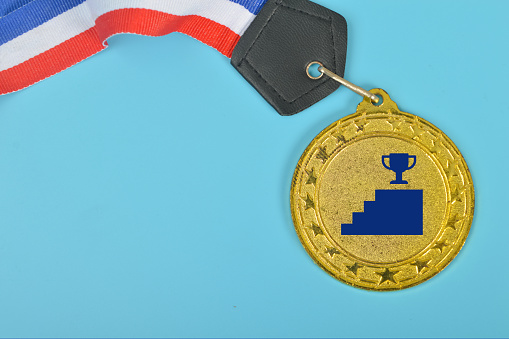 An empty gold medal with copy space is a representation of the concept of celebration and ceremony, as well as a symbol of victory and sporting achievements.