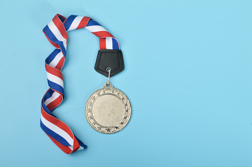 An empty silver medal with copy space is a representation of the concept of celebration and ceremony, as well as a symbol of victory and sporting achievements.