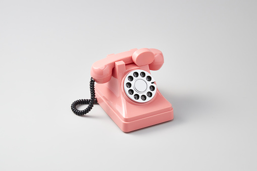 retro pink rotary dial phone, isolated on white background