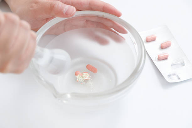 istock Milling instruction and pharmacist. There are tablets in a mortar, and the pharmacist is crushing them with a pestle. 1485614707
