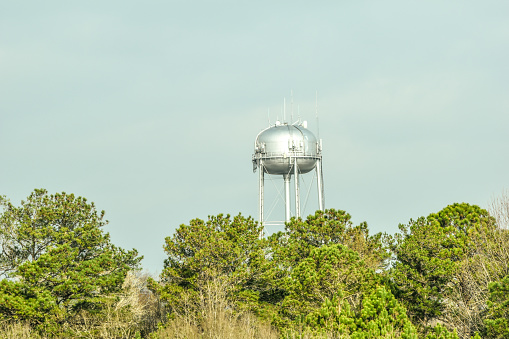 A water tower rises above the trees.