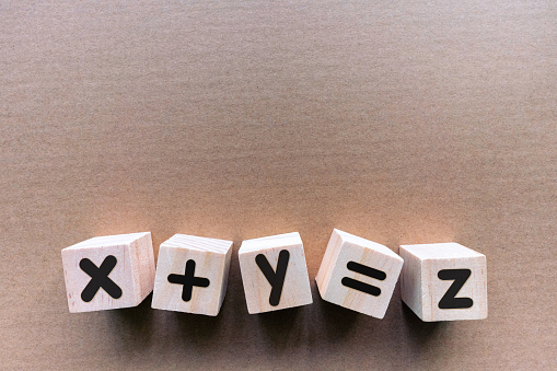 Mathematical symbol with toy block on brown paper background.