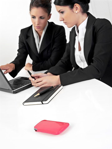 Businesswomen in a office meeting with laptop and smart phone