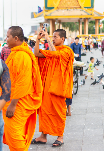 Phnom Penh,Cambodia-January 4th 2023: Monks of all ages from the nearby temples, mingle with the rest of the capital city's population,who come here in their droves to eat and relax,in the evening.