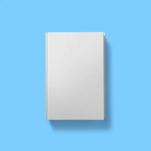 Back to school concept , hard cover blank white open dust jacket partially off isolated on blue.