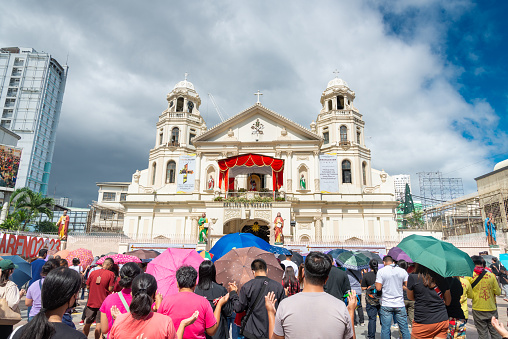Manila,The Philippines-Jan 07 2023: People gather for prayers outside Quiapo Church,the day before the Traslacion,or procession walk,to commemorate the Feast of the Black Nazarene,or Jesus Christ.