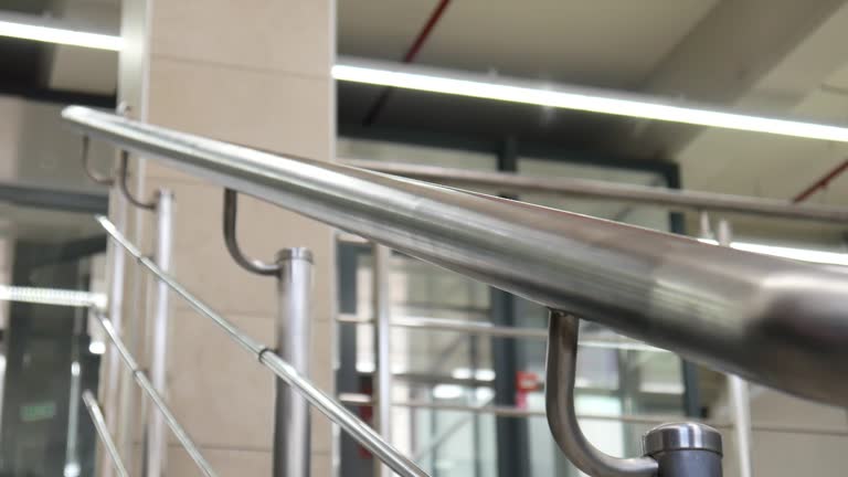 A man going down the stairs holding on to a handrail close-up