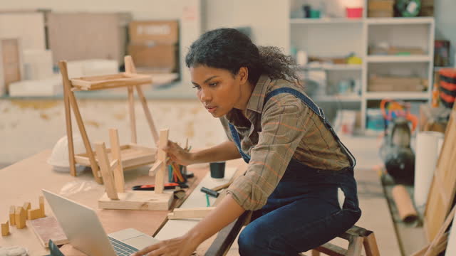 Woman carpenter working on making furniture