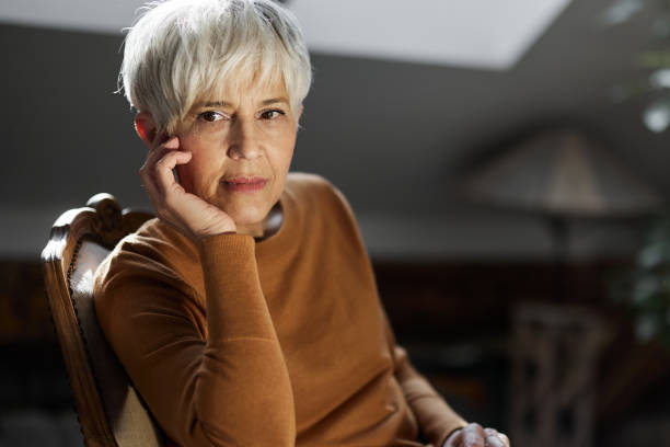 istock Relaxed senior woman day dreaming on chair at home. 1485646423