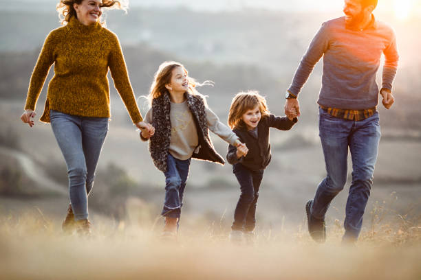 istock Happy family having fun while holding hands and running in autumn at sunset. 1485646569