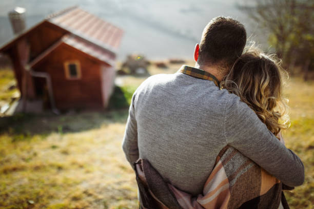 istock Back view of embraced couple looking at view from a hill. 1485647893