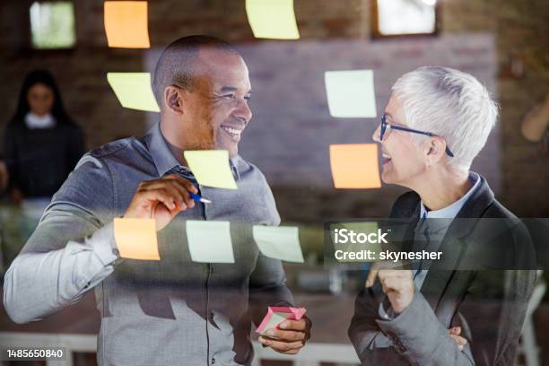 Happy Business Colleagues Talking While Making Mind Map On Glass Stock Photo - Download Image Now