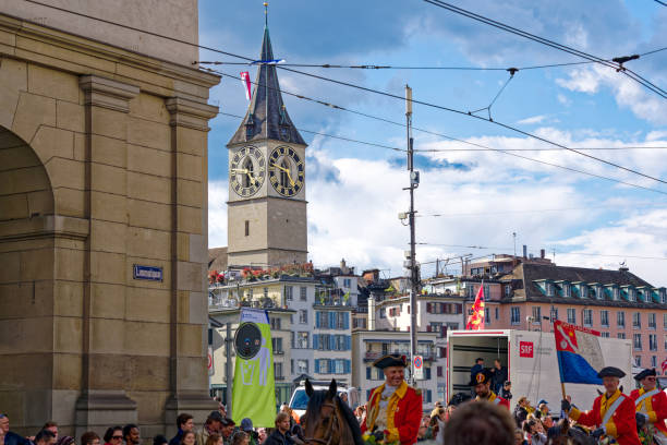 cidade velha com igreja medieval com decoração de bandeira por causa do famoso festival de primavera sechseläuten na cidade suíça. - sechseläuten - fotografias e filmes do acervo