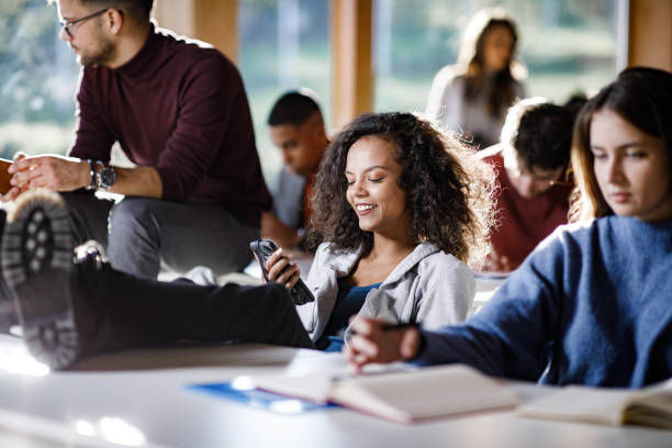 istock Happy student text messaging on cell phone during a break in the classroom. 1485651820