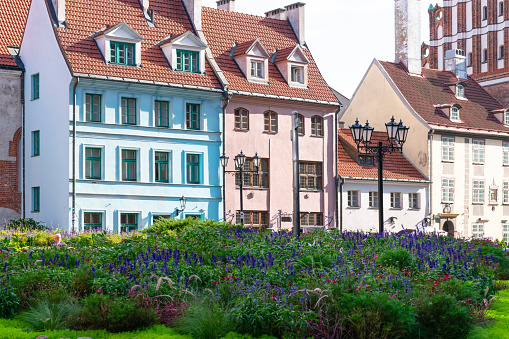 Riga, Latvia, September, 17, 2019: Colorful houses in center of old town Riga in art nouveau style with flowerbed and street lamp.