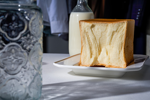 Hand shredded and sliced raw toast bread and milk, breakfast scene