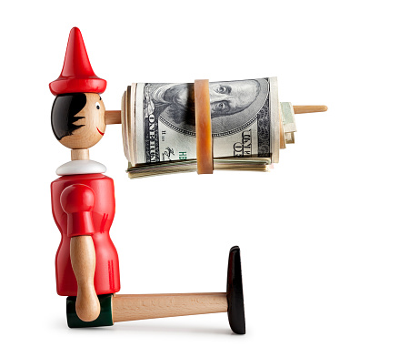 Pinocchio with money in his nose isolated on white background.