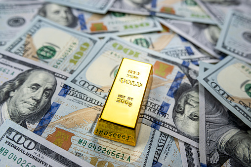 100 dollar bill with gold bars as finance background. \n Concept of investment and saving, wealth