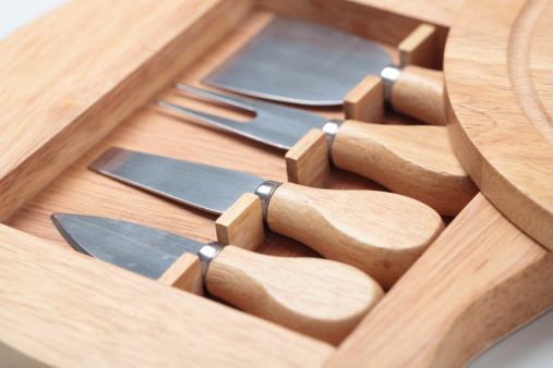 Set of four cheese knives and wooden cutting board