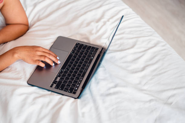 istock Laptop on empty bed,Caucasian woman laying on bed using laptop 1485663511