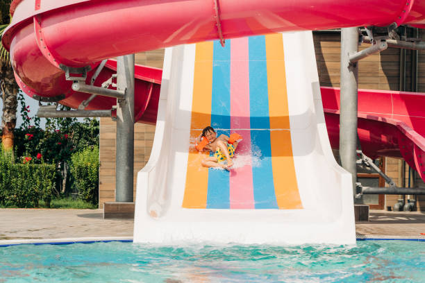 istock Child boy laughing while slide in pool after going down water slide at sunny day in water Aqua park. Kid refreshing at heat weather, active vacation and healthy lifestyle. Happy summer 1485663627