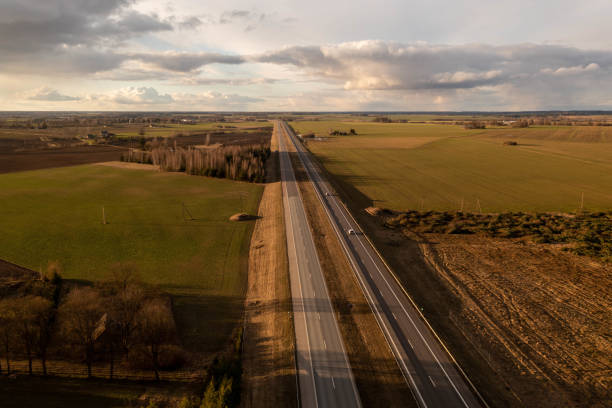 istock Drone footage of highway surrounded by agriculture fields and forest 1485667633