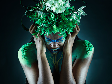 Frustrated, nature and mother earth model feeling sad from climate change in studio. Costume makeup, angry and black person with isolated and dark background upset about pollution and environment