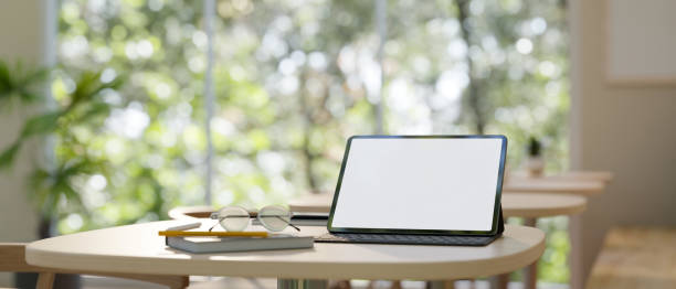 istock Workspace with tablet mockup on a wood table in minimal cafe co-working space. 1485669249