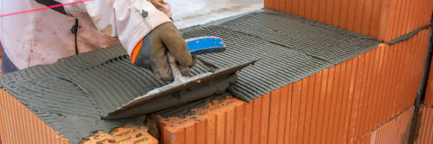 bricklayer at work at new house in construction stock photo