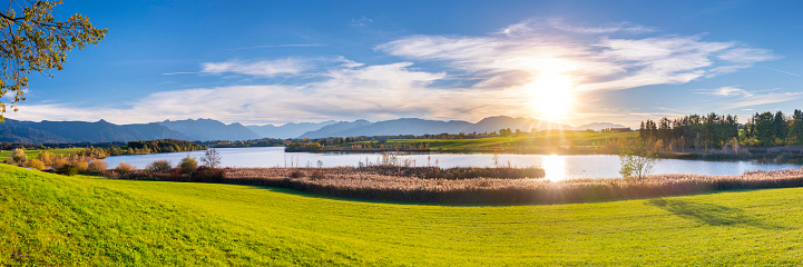panoramic landscape with lake at springtime in front of mountain range