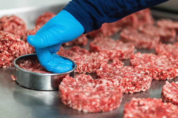 istock Hand of a Chef Preparing Burgers 1485675572