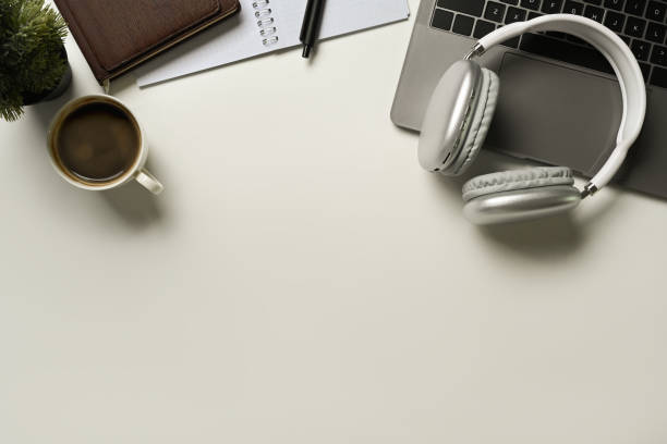 istock Top view of laptop, headphone, empty notepad and coffee cup on white table. Copy space for your text. 1485676876